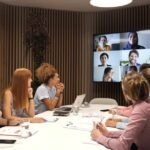 Diverse business people in meeting room attending remote conference, slow motion video